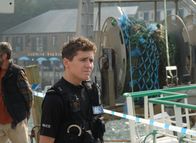 Beyond Paradise – PC Kelby Hartford (Dylan Llewellyn) hat das Boot absperren lassen, auf dem die Passagierin als vermisst gemeldet wurde.