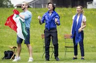 Hubert und Staller – Fabrizio D’Angelo (Antonio di Mauro, M. mit Komparse, l.) und seine Frau Lucia (Sarah Mathilda Libbertz, l.) betreiben eine italienische Gaststätte neben dem Fußballplatz.