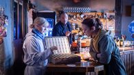 SOKO Wismar – In der Kneipe SPUTNIK stoßen die Kommissare Lars Pöhlmann (Dominic Boeer, M.) und Karoline Joost (Nike Fuhrmann, r.) auf einen Sparschrank. Die Stammgäste des SPUTNIKS können hier regelmäßig Geld hineinwerfen und so etwas sparen. Kriminaltechnikerin Stefanie Horn (Nicole Ernst, l.) hat allerdings auch am Sparschrank Kratzspuren entdeckt. Ist Kneipenwirt Felmy einem Überfall zum Opfer gefallen? Auch aus der Kasse fehlt Geld.