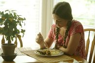 Tödliche Stille – A young girl sits at a dining table with a plate of food.