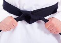 Judo: World Tour – Closeup of a martial arts man tying his black belt
