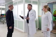 In aller Freundschaft – Silvio Vollinger (Martin Ontrop, li.) erkundigt sich besorgt nach seiner Frau, die nach einem schweren Autounfall in die Sachsenklinik eingeliefert wurde. Ihr Zustand ist äußerst kritisch und Dr. Roland Heilmann (Thomas Rühmann, mi.) muss sie operieren. Er bittet Schwester Miriam (Christina Petersen, re.), sich um Herrn Vollinger zu kümmern.