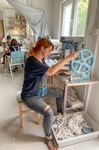 GEO Reportage – In der Werkstatt der Familie Jaksic bereitet Dina kleine Plättchen für das berühmte Kalksteinkleid vor.