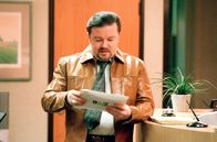 The Office – David Brent (Ricky Gervais) Picture Shows: David in his new leather jacket Series Two of the BAFTA winning comedy, the painfully accurate portrait of the modern work-place that leaves you either counting your blessings or questioning your career. David Brent tries to assimilate the new Swindon intake, a group of well-trained and highly motivated personnel. It should be an easy job. Sadly, someone forgot to tell them they're meant to laugh at everything David says. Unlucky-in-love Tim finds his fortune changing, we discover there's more to demure Dawn than first meets the eye, but there's even less to Gareth. The photography may only be used for publicity purposes in connection with the broadcast of the programme as licensed by BBC Worldwide Ltd and must carry the shown copyright legend. It may not be used for any commercial purpose without a licence from the BBC.