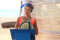Death in Paradise – Die Bürgermeisterin Catherine Bordey (Élizabeth Bourgine) verleiht einen Preis an den Commissioner Selwyn Patterson (Don Warrington).