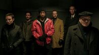 Captive State – (L - R) Caitlin Ewald as Anita, James Ransone as Ellison, Jonathan Majors as Rafe, Ben Daniels as Daniel, Lawrence Grimm as Hayes, and Gus Van Swearingen as Eddie the Priest in Rupert Wyatt's CAPTIVE STATE, a Focus Features release. Credit: Parrish Lewis / Focus Features; CS_Day16_0397.arw; (L - R) Caitlin Ewald as Anita, James Ransone as Ellison, Jonathan Majors as Rafe, Ben Daniels as Daniel, Lawrence Grimm as Hayes, and Gus Van Swearingen as Eddie the Priest in Rupert Wyatt's CAPTIVE STATE.