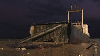 Enthüllt: Geheimnisse der Meere – Wrack der Lucona: Das trockengelegte Wrack der Lucona zeigt das im Schlamm eingegrabene Heck des Schiffes und Bombenschäden an den Seitenwänden. Das Schiff wurde im Januar 1977 durch eine Zeitbombe versenkt, die der österreichische Geschäftsmann Udo Proksch an Bord platziert hatte. (National Geographic für Disney)