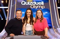 Quizduell - Olymp – Moderatorin Esther Sedlaczek (M.) mit den Kandidat:innen des Teams "Raue": Tim Raue (l.), Koch und Katharina Raue (r.), Chefredakteurin.