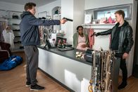 SOKO Leipzig – Die beiden Bankräuber Kevin Rother (Vincent Krüger, l.) und Fabio Bohnenkamp (Max Schimmelpfennig, r.) verbarrikadieren sich auf ihrer Flucht in einem kleinen Laden und nehmen die hochschwangere Besitzerin, Fatima Deil (Blessing Osadolor, M.), als Geisel.
