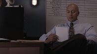 Detective Demery: Mord ist sein Metier – Demery looks at a page at his desk.