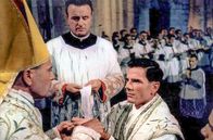 Der Kardinal – Kardinal Quarenghi (Raf Vallone, li.) weiht Stephen (Tom Tryon, 3.v.l.) zum Priester. Der Kardinal erkennt früh Stephens Begabung und wird zu seinem Förderer und Mentor.