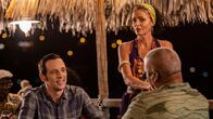 Death in Paradise – Polizeichef Selwyn Patterson (Don Warrington, r.) versucht Detective Neville Parker (Ralf Little, l.) bei einem Glas Rum dazu zu überreden, die Insel nicht zu verlassen, während Catherine Bordey (Elizabeth Bourgine, M.) gelegentlich Rum für sie nachschenkt.