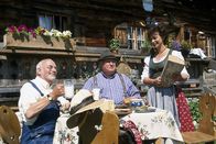 Löwenzahn Classics – Auf einer Almhütte machen Peter (Peter Lustig, l.) und Nachbar Paschulke (Helmut Krauss, r.) eine zünftige Brotzeit und erkundigen sich bei der Sennerin (Conny Glogger) nach der Silberwurz, einer Heilpflanze, die in den Alpen wachsen soll.