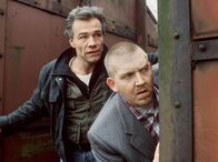 Tatort – Die beiden Kommissare Ballauf und Schenk (Klaus J. Behrendt und Dietmar Bär, rechts) beobachten während ihres ersten gemeinsamen Falls einen Tatverdächtigen auf dem Güterbahnhof.