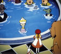 Alice im Wunderland – Zu spät. Alice hoffte, das große Hundebaby einfangen zu können, bevor es Schaden anrichten kann. Doch aus Angst vor dem Riesenhund, haben sich die Schachkönigin und ihre Gäste ins königliche Schwimmbecken gerettet. „Diese Party dürfte ins Wasser gefallen sein“, meint die Schachkönigin und versucht das Beste daraus zu machen.