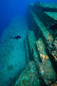 Mysteriöse Inseln – Ein Taucher untersucht die Sandsteinstruktur des unterseeischen Yonaguni-Denkmals. MYSTERIOUS ISLANDS nimmt die Zuschauer mit auf ein unvergessliches Abenteuer zur Erkundung der außergewöhnlichsten und rätselhaftesten Inseln unseres Planeten. (Kredit: MICHAEL PITTS/NATURE PICTURE LIBRARY/SCIENCE PHOTO LIBRARY)
