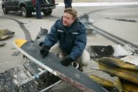 Mayday - Alarm im Cockpit – REENACTMENT - NTSB-Ermittler Tom Haueter (gespielt von Christian Lloyd) entdeckt Farbe, die bei einem tödlichen Flugzeugzusammenstoß am Quincy Regional Airport auf ein Wrackteil übertragen wurde.