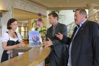 Die Rosenheim-Cops – Die Kommissare (Igor Jeftic, M.; Joseph Hannesschläger, r.) erhoffen sich von Rezeptionistin Helga Schütt (Jutta Schmuttermaier, l.) neue Erkenntnisse.