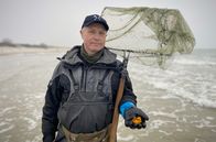 Strände Europas – Bernsteinsammler Audrius zeigt seine Ausbeute nach einem Sturm.