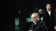 Die Ermittlung – Backdrop Stage zu "Die Ermittlung". Regisseur RP Kahl hat das Theaterstück "Die Ermittlung“ von Peter Weiss mit 60 Schauspielerinnen und Schauspielern für die Kinoleinwand inszeniert. Das 1965 uraufgeführte "Oratorium in 11 Gesängen" basiert auf Aufzeichnungen, Zeitungsartikeln und Protokollen des ersten Frankfurter Auschwitz-Prozesses. Im Bild, von links: Rainer Bock als Richter und Clemens Schick als Ankläger.