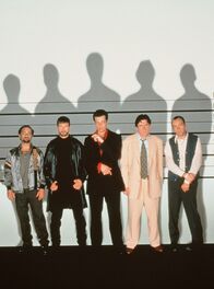 Die üblichen Verdächtigen – Nach einem Raubüberfall werden die vorbestraften Kleinkriminellen Todd Hockney (Kevin Pollak, 1. v. li.), McManus (Stephen Baldwin, 2. v. li.), Fenster (Benicio Del Toro, 3. v. li.), Dean Keaton (Gabriel Byrne, 4. v. li.) und Roger "Verbal" Kint (Kevin Spacey) verhaftet. Im Gefängnis werden sie zu Komplizen.