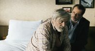 Oktober November – Der Vater (Peter Simonischeck, links) wird nach seinem Zusammenbruch vom Arzt (Sebastian Koch) untersucht.