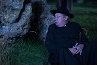 Father Brown – Father Brown (Mark Williams) versteckt sich hinter einem Stein.