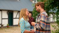 Rote Rosen – Michael (Hanno Friedrich m.) hat Rückenschmerzen und kann Carla (Maria Fuchs l.) nicht beim Einrichten der Pferdeboxen helfen. Simon (Thore Lüthje r.) springt für ihn ein