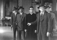 Ich beichte – Kriminalkommissar Larrue (Karl Malden, re. vorne) hält Pfarrer Michael Logan (Montgomery Clift, Mi.) zurück, während bewaffnete Polizisten bereitstehen.