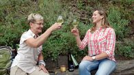 Wunderschön! – Tamina (r) trinkt mit der Kultur- und Weinbotschafterin Marie-Theres Heß Wein, nachdem sie erfolgreich den Calmont Klettersteig bezwungen haben.