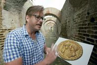 Neros Stadt der Lüste – Archäologieprofessor Kevin Dicus mit einer Münze aus dem ersten Monat von Neros Regierungszeit, die den Kaiser mit seiner Mutter Agrippina zeigt.