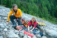 Die Bergretter – Die Bergretter Markus (Sebastian Ströbel, l.) und Katharina (Luise Bähr, r.) finden den abgestürzten und schwer verletzten Jan Fugain (Patrick G. Boll, M.). Während Katharina Strasser ihn erstversorgt, erkennt Markus, dass der Patient kein Unbekannter ist & in Verbindung mit der Sendung bei Nennung ZDF/Thomas R. Schumann