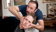 Der Tatortreiniger – „Ich zeig Ihnen was“, sagt Schotty (Bjarne Mädel) und präsentiert Dagmar (Annika Meier) etwas Lustiges in der Wohnung.