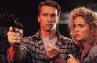Total Recall – Der Bauarbeiter Douglas Quaid (Arnold Schwarzenegger, l.) führt eigentlich ein zufriedenes Leben mit seiner attraktiven Frau Lori (Sharon Stone, r.), doch immer wieder träumt er von einem anderen Leben und einer fremden Frau. Was hat das zu bedeuten?
