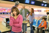 The Middle – Während Mike (Neil Flynn, hinten l.) sich mit einem Ehepaar (Jim Abele, 3.v.r. und Bekka Prewitt, 2.v.r.) und ihrem Sohn (Skyler James Sandak, r.) unterhält, bekommt Frankie (Patricia Heaton, vorne l.) einen beunruhigenden Anruf von ihren Kindern ...