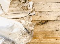 Auf Streife – Detail view of beautiful white wedding dress train after outdoor wedding in rainy day on wooden board background.