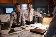 Mayday - Alarm im Cockpit – REENACTMENT - Lead Investigator (played by Oscar Hsu) finds the work order and looks up to consult with other investigators (played by background preformers). (Photo Credit: Cineflex/Ian Watson)