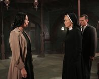 American Horror Story – Jahr 1964: Schwester Jude Martin (Jessica Lange, M.) war eigentlich überzeugt, dass es sich bei der Patientin tatsächlich um Anne Frank (Franka Potente, l.) handelt, bis plötzlich ihr Ehemann Jim (David Chisum, r.) auftaucht, der etwas anderes behauptet ...