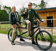 Hubert ohne Staller – Hubert (Christian Tramitz, l.) und Girwidz (Michael Brandner, r.) steigen notgedrungen aufs Tandem um und Girwidz verlangt von Hubert mehr Teamwork.