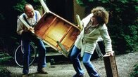 Löwenzahn Classics – Trude (Ute Fitz-Kaska, r.) hilft Peter Lustig (Peter Lustig, l.) beim Umzug - doch wohin wird Peter ziehen? In ein Schiff, einen Eisenbahnwaggon oder in einen Bauwagen?