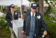 Mayday - Alarm im Cockpit – NTSB-Ermittler Al Diehl (gespielt von Thomas Mitchell, links) und ein weiterer NTSB-Ermittler tragen den FDR und das CVR von United Airlines Flug 173. Die Kisten werden zu den NTSB-Labors in Washington transportiert. Die Daten sollen erklären, warum das Verkehrsflugzeug mit 181 Passagieren und 8 Besatzungsmitgliedern an Bord 6 Meilen vor dem Portland International Airport in ein Waldgebiet stürzte. Die Besatzung hatte beim Anflug auf Portland ein Problem mit dem Fahrwerk gemeldet und beschlossen, den Flughafen zu umrunden, um das Problem zu beheben. Die Ermittler fanden heraus, dass der DC-8 während des Kreisens der Treibstoff ausging. photo credit: Cineflix/Ian Watson