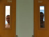 Lockdown - Hinter Gittern – Male inmates look out ther cell door windows in men's housing module