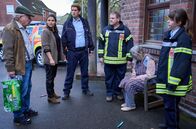 Mord mit Aussicht – Hans Zielonka (Michael Hannemann, l.), Marie Gabler (Katharina Wackernagel, 2.v.l.), Heino Fuß (Sebastian Schwarz, 3.v.l.), Arthur Brandt (Felix Vörtler, 3.v.r.) und Jenny Dickel (Eva Bühnen, r.) kümmern sich um Waltraud Runkelbach (Friederike Frerichs, 2.v.r.), die Opfer einer Briefbombe wurde.
