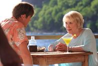Death in Paradise – Humphrey (Kris Marshall, l.) und Tante Mary (Wendy Craig, r.) sitzen bei einem Cocktail beieinander. Mary hat ihrem Neffen etwas Wichtiges mitzuteilen.