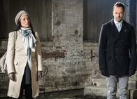 Elementary – Holmes (Jonny Lee Miller, r.) und Watson (Lucy Liu, l.) statten Moriarty einen Besuch im Gefängnis ab. Dabei stellen sie fest, dass sie dort ein ziemlich angenehmes Leben führt, denn sie kann ihrer Leidenschaft nachgehen und malen ...