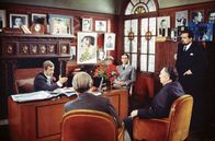 Stavisky – Stavisky (Jean-Paul Belmondo, li.) mit seinen Vertrauten und Beratern in seinem Arbeitszimmer