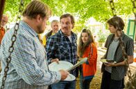 Alles finster – Edi, Ulli und Jakob stehen vor Jens bei der Essensausgabe. Jens will Ulli nichts zu Essen geben, weil sie nicht einkalkuliert ist. Vorne, l-r: Jens (Michael A. Grimm), Edi (Harald Windisch), Ulli (Maria Hofstätter), Jakob (Enzo Gaier).