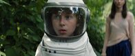 Grüße vom Mars – Tom (Theo Kretschmer) kommt im Garten seiner Großeltern an. Er trägt seinen Astronautenanzug und Helm.