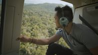 Spuren verlorener Städte mit Albert Lin – National Geographic Explorer, Albert Lin, looks out on the land below during a helicopter flight to the El Zotz archaeological site in the Petén department of Guatemala. (Credit: National Geographic)
