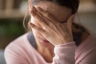 Visite (ARD-alpha) – Müde junge Frau, die ihre Stirn berührt, mit Kopfschmerzen, Migräne oder Depression